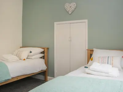 a bedroom with two beds and a closet at Belmont Bridge in Oswestry