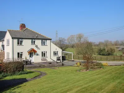 a white house with a yard and a fence at Belmont Bridge in Oswestry