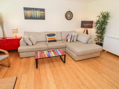 a living room with a couch and a table at Redwood in Harlech