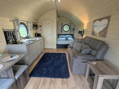 a living room with a couch and a bed at Stapeley Pod in Shrewsbury