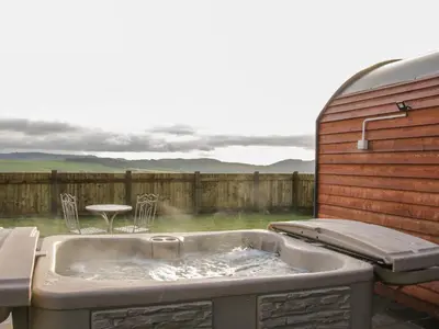 a bath tub with a table and chairs in a backyard at Stapeley Pod in Shrewsbury