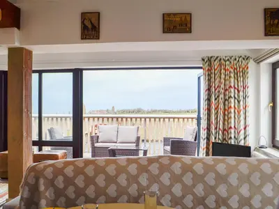 a living room with a bed and a balcony at Plas Bach in Llanon
