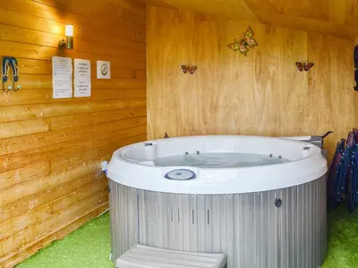 a jacuzzi tub in a room with wooden walls at Tyncoed - Uk32238 in Lower Chapel