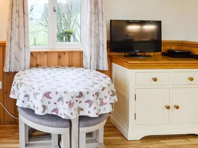 a room with a table and a tv and a table and chair at Tyncoed - Uk32238 in Lower Chapel