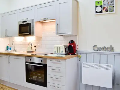 a kitchen with white cabinets and a counter top at Ty Nant - Uk32239 in Lower Chapel