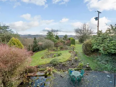 a garden with a bench and a pond at Pen Y Crug in Beulah