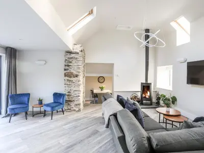 a living room with a couch and chairs and a fireplace at Drovers Barn in Corwen