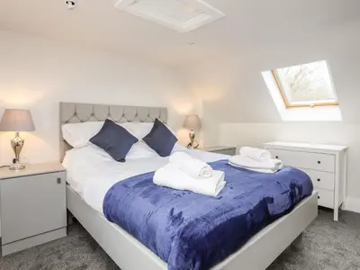 a bedroom with a large bed with towels on it at Drovers Barn in Corwen