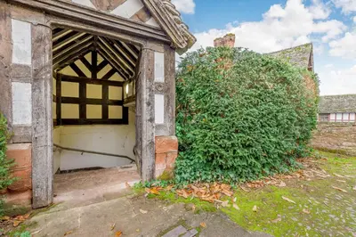 an entrance to an old building with a large bush at The Generals Quarters at Pitchford Estate in Shrewsbury