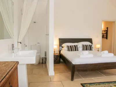 a bedroom with a bed and a sink and a tub at Treehouse Barn at Pitchford Estate in Shrewsbury