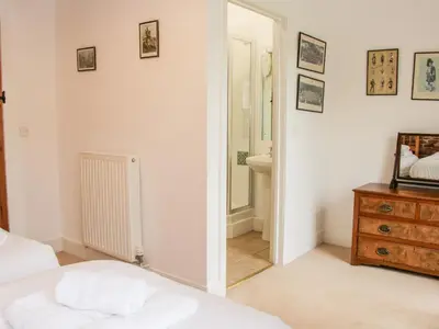 a bedroom with a bed and a mirror and a sink at Stockbatch Granary at Pitchford Estate in Shrewsbury
