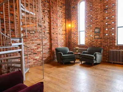 a room with two chairs and a brick wall at Windy Mundy Farm at Pitchford Estate in Shrewsbury