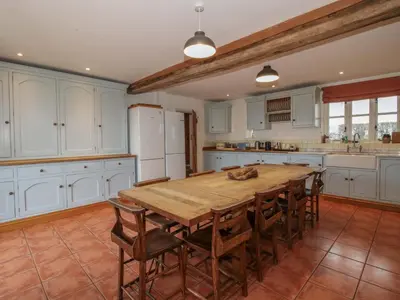 a large kitchen with a wooden table and chairs at Windy Mundy Farm at Pitchford Estate in Shrewsbury