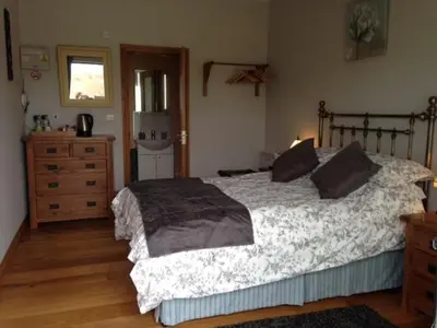 a bedroom with a large bed and a dresser at Bryn Derw in Talsarnau