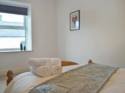 a bedroom with a bed with towels on it at Bristol House in New Quay