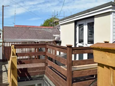 a wooden deck with a wooden railing on a house at Bristol House in New Quay