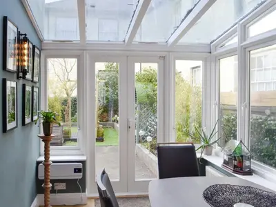 a conservatory with a table and chairs and a glass door at The Apartment in Brecon