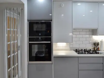 a white kitchen with white cabinets and an oven at The Apartment in Brecon