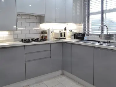 a white kitchen with white cabinets and a sink at The Apartment in Brecon