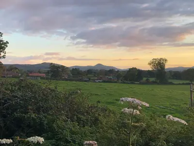 a field of grass with mountains in the distance at Wisteria Cottages are self catering cottages in a beautiful village location in Dorrington