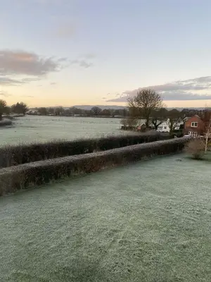 a field of grass with a house in the background at Wisteria Cottages are self catering cottages in a beautiful village location in Dorrington
