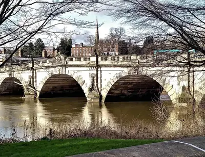 a bridge over a river in a city at Wisteria Cottages are self catering cottages in a beautiful village location in Dorrington
