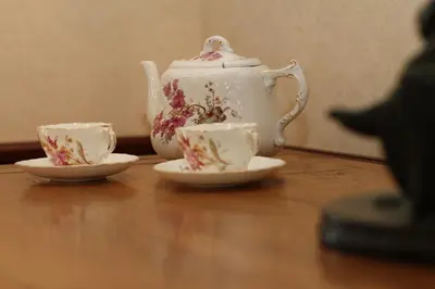 two tea cups and a teapot on a wooden table at Ystumgwern Luxury Barn Conversions in Dyffryn