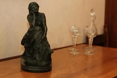 a statue of a woman sitting on a table with wine glasses at Ystumgwern Luxury Barn Conversions in Dyffryn