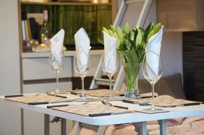 a table with four wine glasses and a vase of flowers at The Fox Den in Rhayader