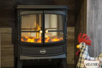a stove with a fire inside of it at Woodland Escape in Nantmel