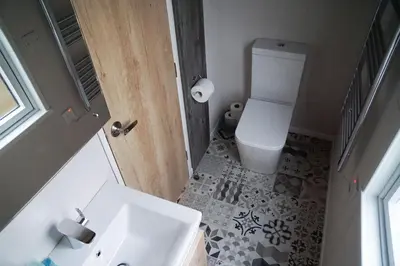 a bathroom with a white sink and a toilet at Woodland Escape in Nantmel