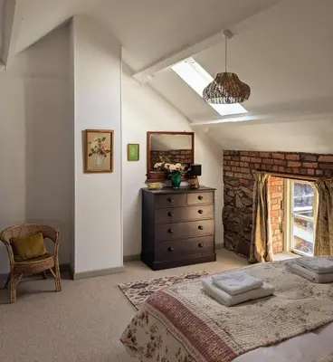 a bedroom with a bed and a mirror and a dresser at Little Underhill in Oswestry