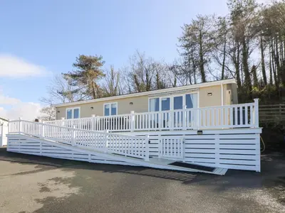 a mobile home with a large white porch at McAuliffe Lodge in Borth