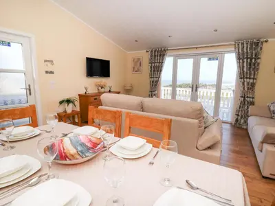 a living room with a table with wine glasses at McAuliffe Lodge in Borth
