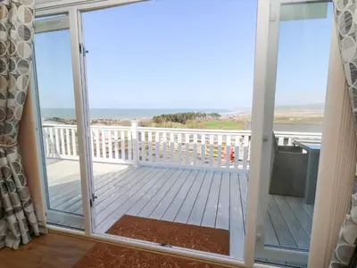 a screened in porch with a view of the ocean at McAuliffe Lodge in Borth