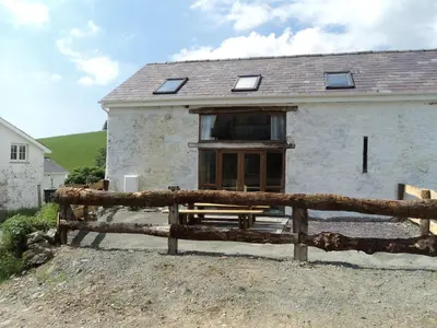 a house with a wooden fence in front of it at Merlin Cottages in Llandovery