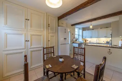 a kitchen with a table and chairs and a refrigerator at Turford House, Ludlow in Ludlow