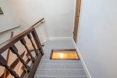 a stairway with a wooden rail and a glass window at Turford House, Ludlow in Ludlow