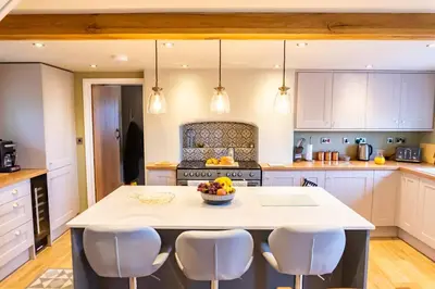 a kitchen with a island with a bowl of fruit on it at The Patches in Shrewsbury