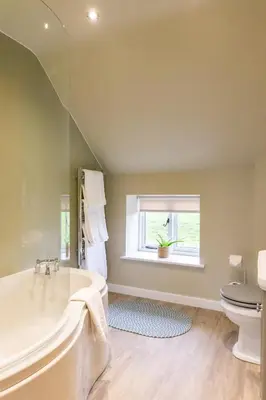 a bathroom with a tub and a toilet and a window at The Patches in Shrewsbury