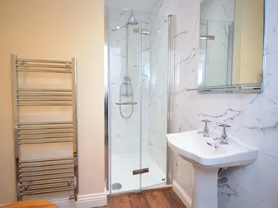 a bathroom with a sink and a shower at Bettws Hall Accommodation in Newtown