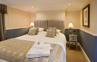 a hotel room with a bed with a towel on it at Bettws Hall Accommodation in Newtown