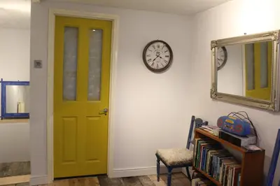 a green door in a room with a clock on the wall at 4BedHouse Leominster Hiking Castles Sleeps7 Wifi in Leominster