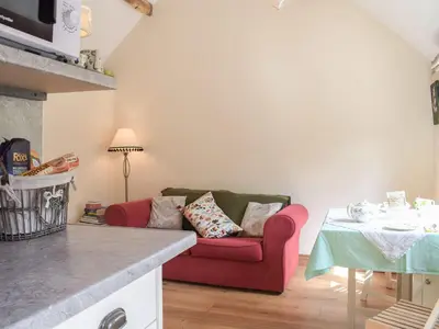 a living room with a red couch and a table at Badgers Den - Uk32084 in Dorstone