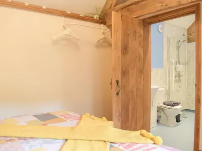 a bedroom with a bed and a bathroom with a toilet at Badgers Den - Uk32084 in Dorstone