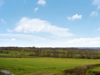 a green field with sheep grazing in the distance at Gooses Roost - Uk32096 in Dorstone