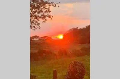 a sunset in a field with the sun setting at Lle Mary - Beautiful views, Hot tub, Secluded, Dog Welcome, Barmouth in Llanddwywe