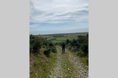 a man walking down a dirt road at Lle Mary - Beautiful views, Hot tub, Secluded, Dog Welcome, Barmouth in Llanddwywe