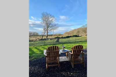 two chairs and a table in a field at Lle Mary - Beautiful views, Hot tub, Secluded, Dog Welcome, Barmouth in Llanddwywe