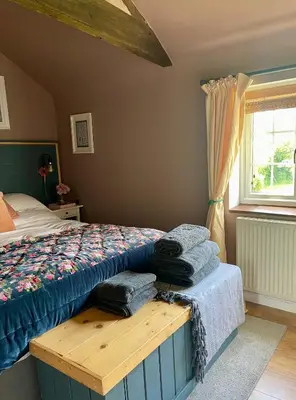 a bedroom with a bed and a window at Archers Cottage in Leominster